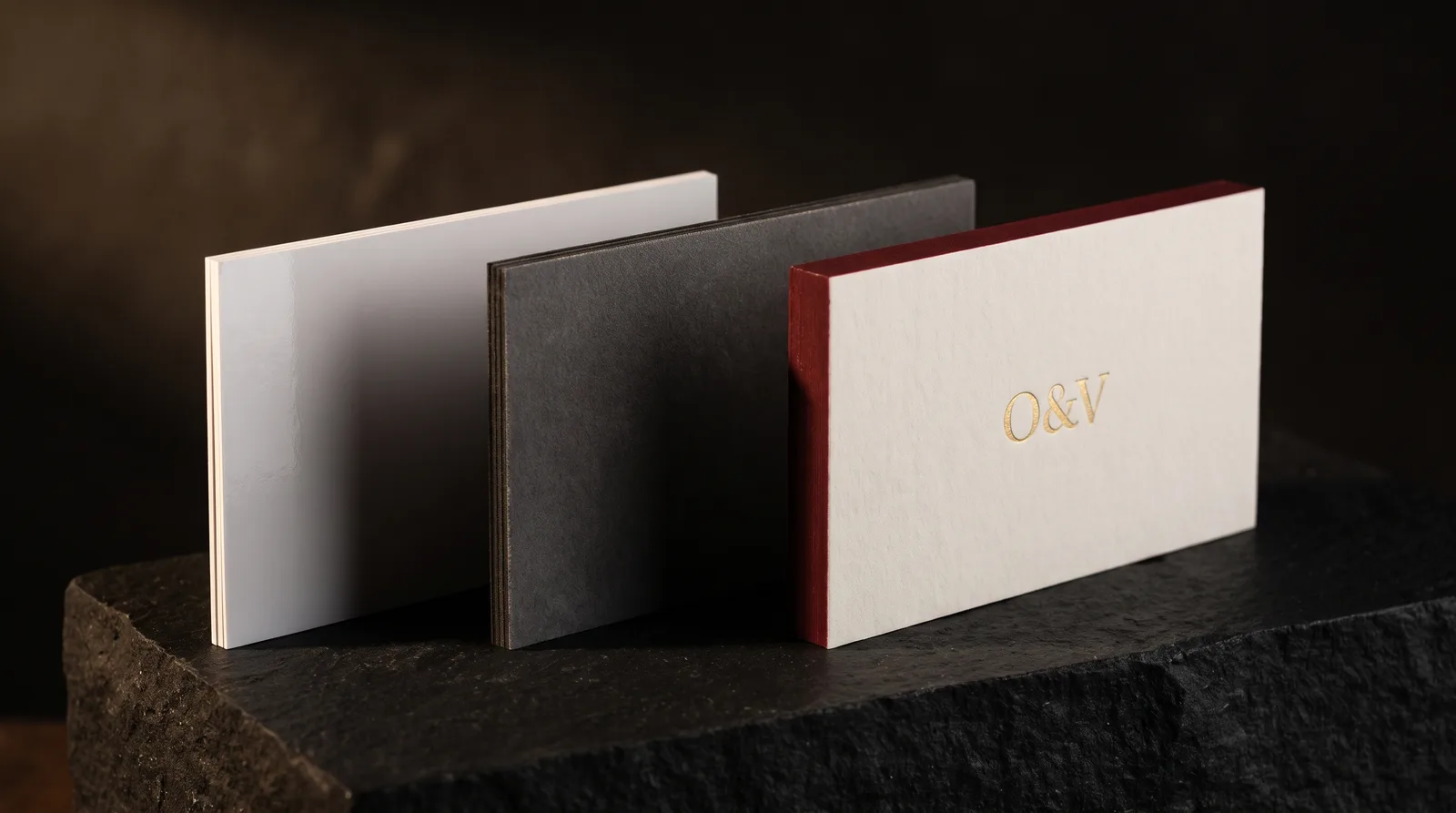Three business cards compared by build: a thin 14pt coated card, an 18pt soft-touch card, and a 32pt cotton card with gold hot foil and a painted edge
