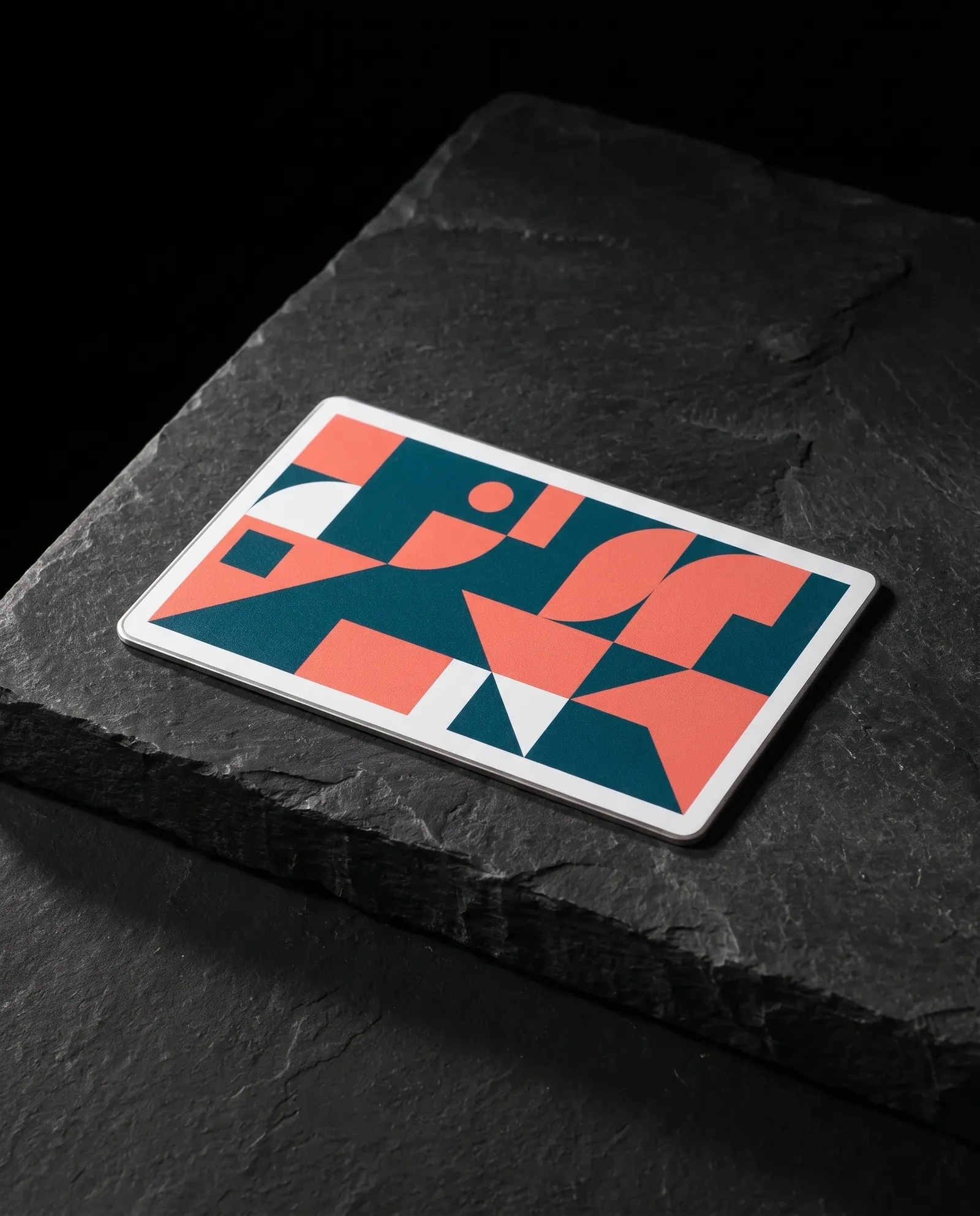 White coated stainless steel business card with a full-color teal and coral printed pattern
