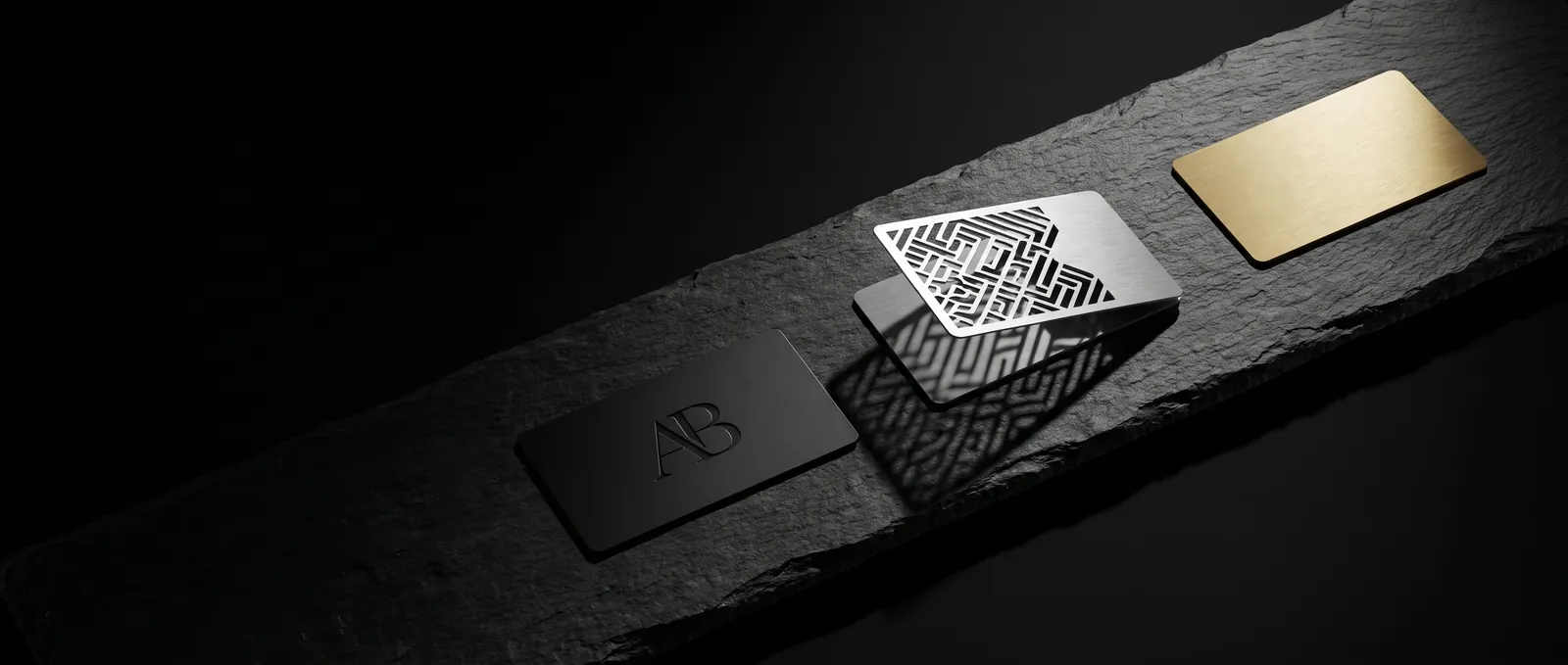 Black, silver cut-out and gold metal business cards lined up on a long slate plinth